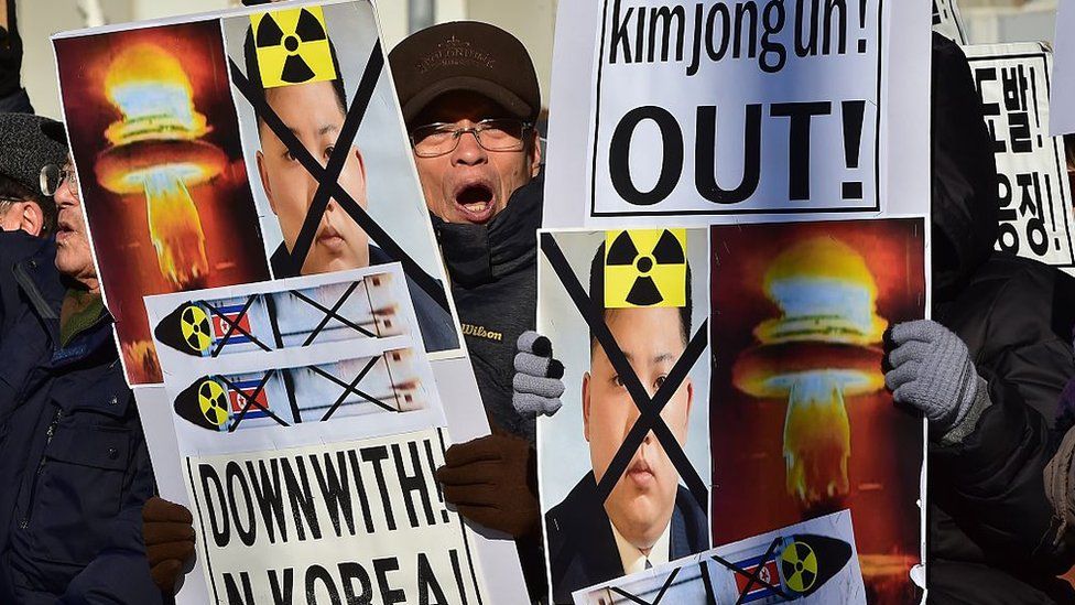 South Korean conservative activists shout slogans with placards showing portraits of North Korean leader Kim Jong-Un during a rally denouncing North Korea's hydrogen bomb test