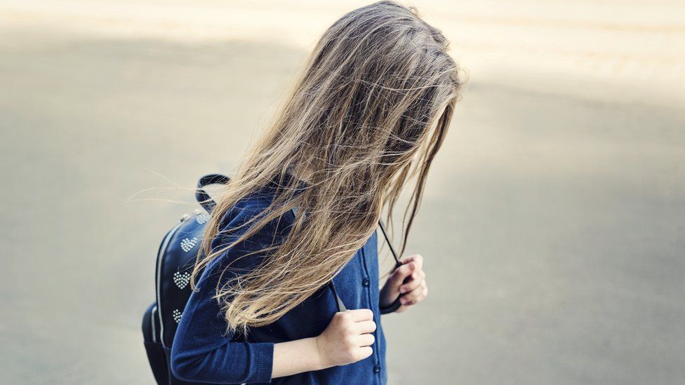 A girl walking with her head down