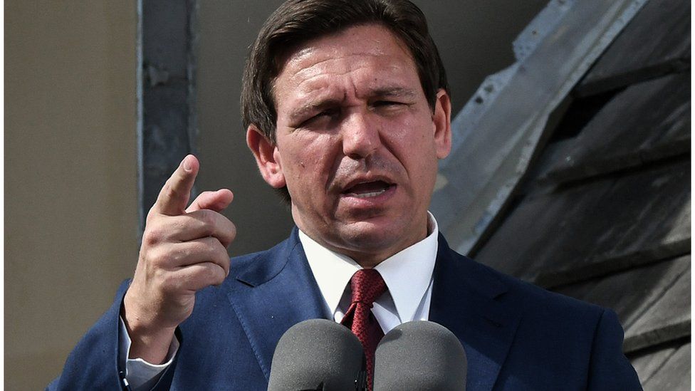 Florida Governor Ron DeSantis speaks into microphones.