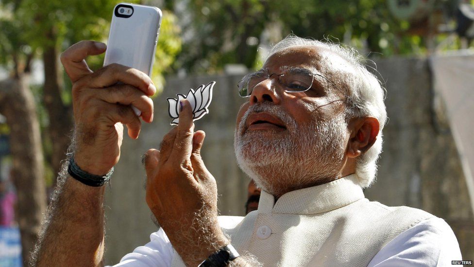 Indian leader Narendra Modi takes a selfie with his phone in Ahmedabad city on 30 April, 2014