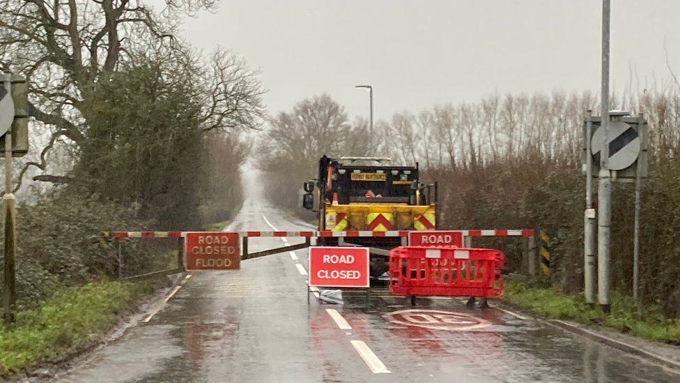 Closed gates and a flood warning sign on the A361