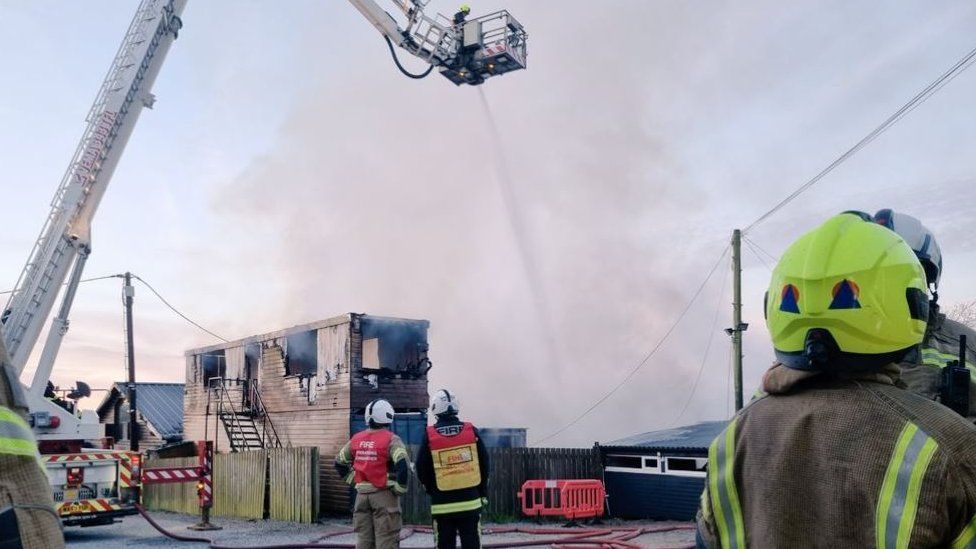 Aerial ladder platform and firefighters at the scene