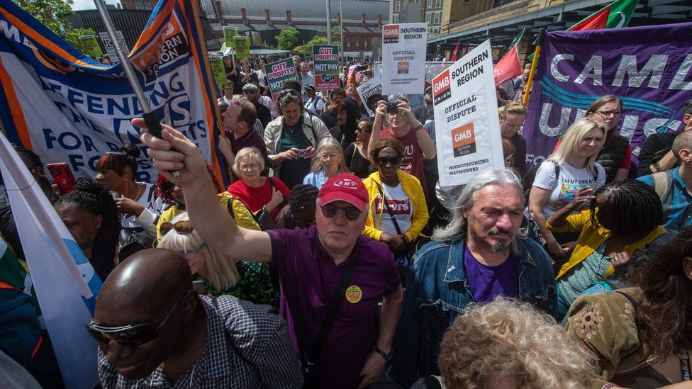 A crowd of railway workers with banners, whilst on strike in June 2022