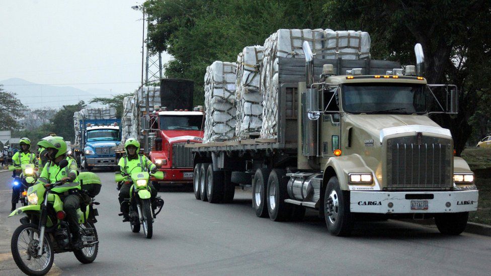 Police escort trucks arriving at a warehouse where humanitarian aid for Venezuela will be stored near the Tienditas bridge between Colombia and Venezuela, Feb. 16, 2019