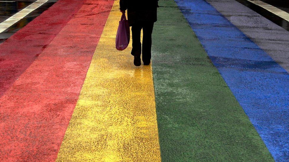 pedestrian walks across rainbow crossing in Sydney