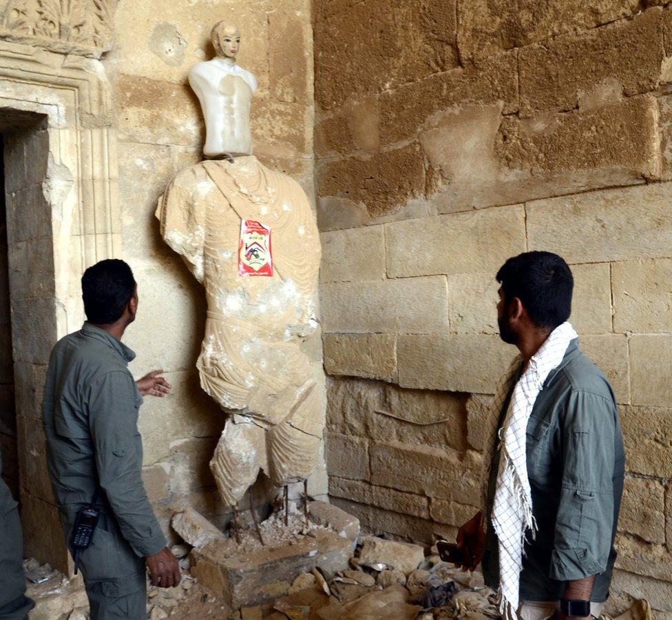 Members of the paramilitary Popular Mobilisation force inspect damage at the ancient city of Hatra in Iraq (28 April 2017)