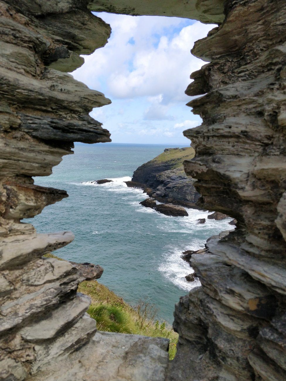 Sea and rocks viewed through a gap in rock