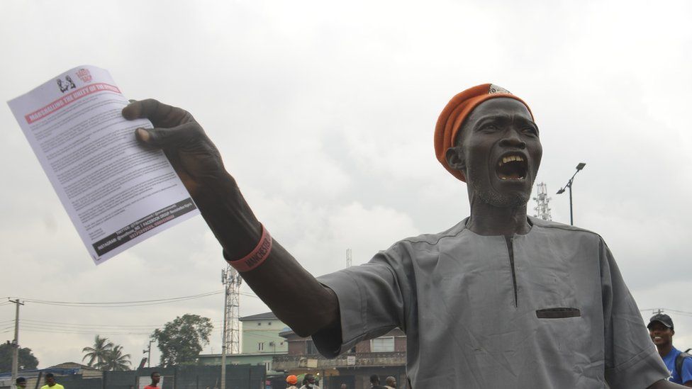 A protestor demanding the resignation of President Buhari as Nigeria marked its 61st year of independence on 1st October. He can be seen holding a leaflet and shouting on the street.