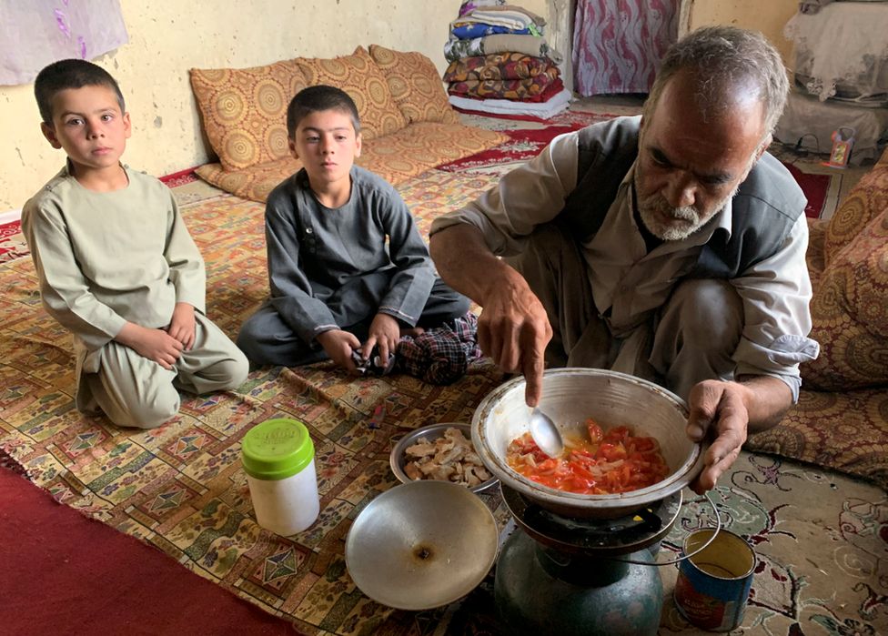 Hashmatullah cooks up bread with onion and tomatoes for his sons