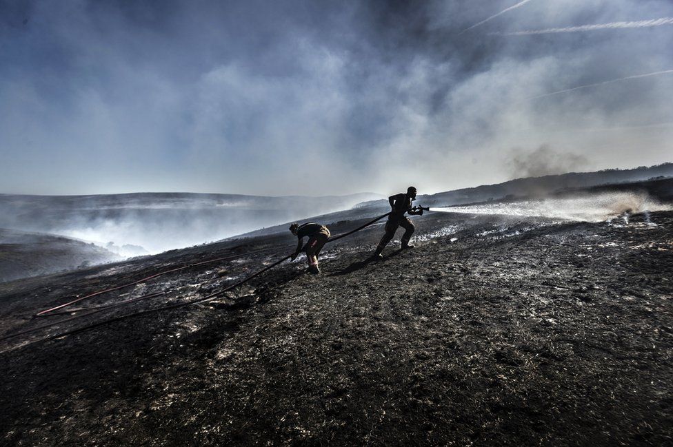 Fire fighters tackle the wildfire on Saddleworth Moor on 28 June 2018.