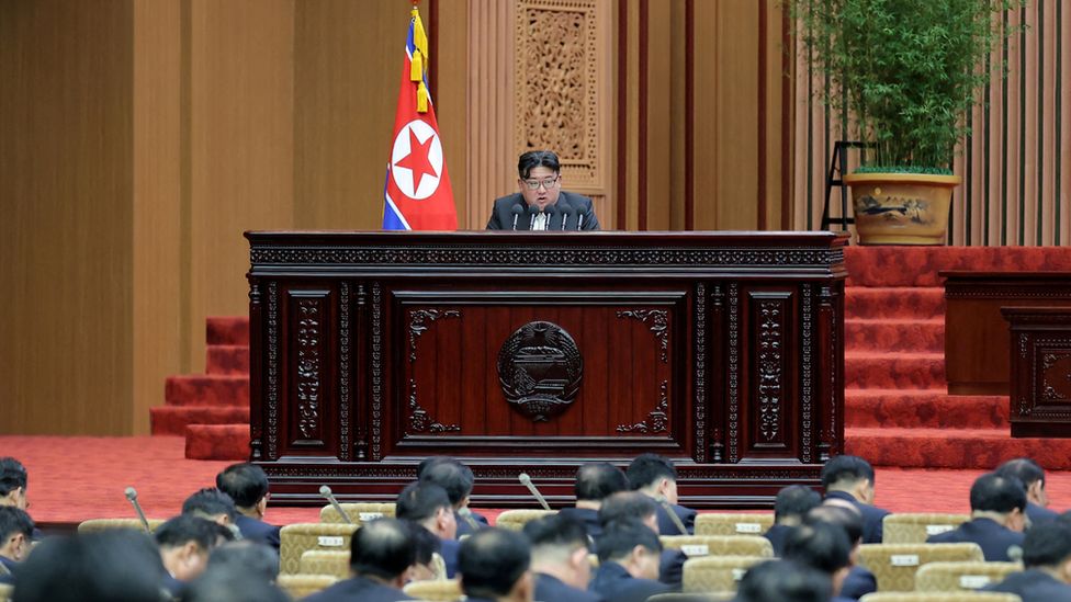 Kim Jong Un at a lectern addresses the Supreme People's Assembly legislators on 15/1