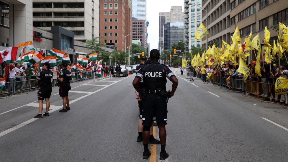 Policiais montam guarda enquanto apoiadores pró-Khalistão se reúnem para uma manifestação em frente ao Consulado da Índia em Toronto, Ontário, Canadá, em 8 de julho de 2023. Contramanifestantes pró-Índia também se reuniram em frente ao Consulado da Índia para um contraprotesto.