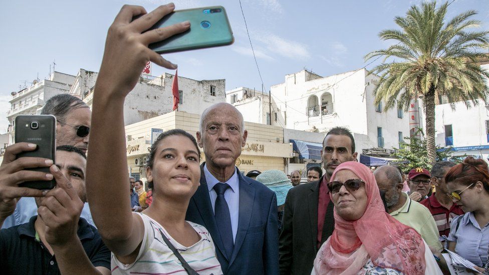 Supporters take pictures with Tunisian presidential candidate Kais Saied