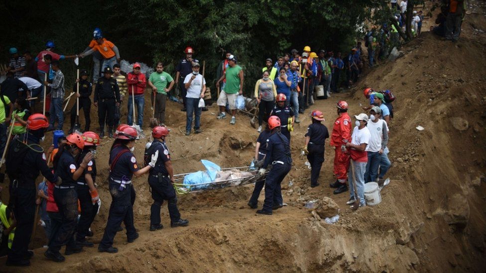 Firemen carry a body recovered from under the debris in the village of El Cambray II, in Santa Catarina Pinula municipality, some 15 km east of Guatemala City, on October 3, 2015 after a landslide late Thursday struck the village.