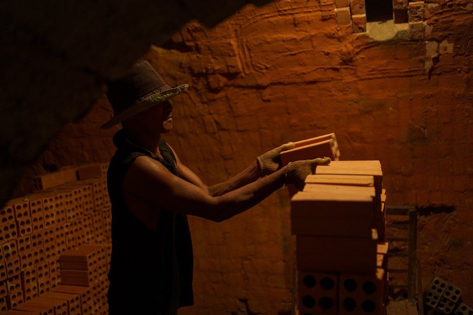 A worker stacking bricks inside the kiln