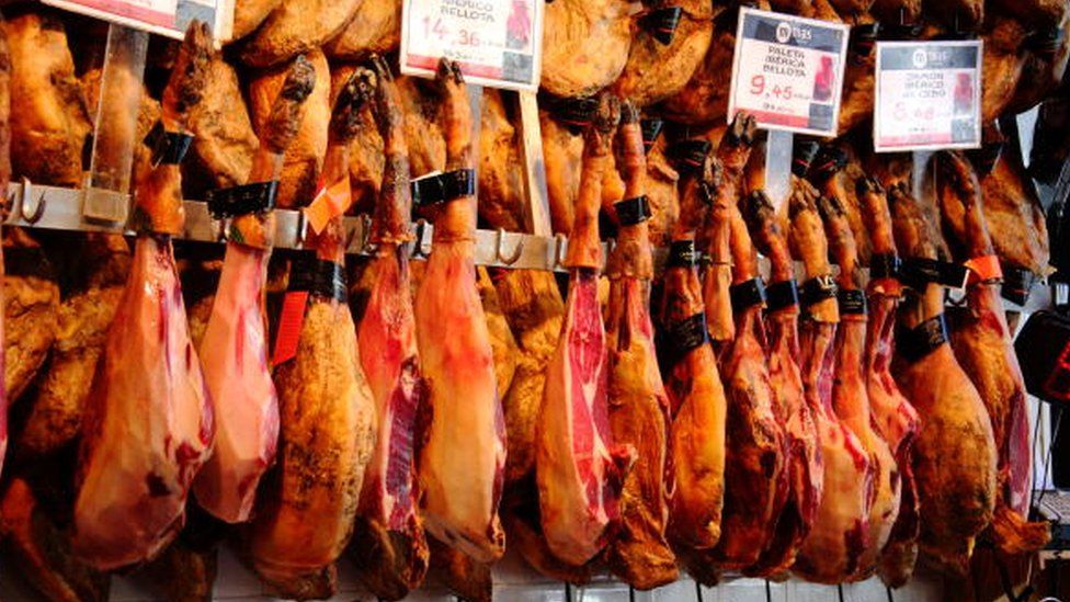 Мясная лавка продает испанскую ветчину на продуктовом базаре Меркадо-де-Сан-Мигель в Мадриде