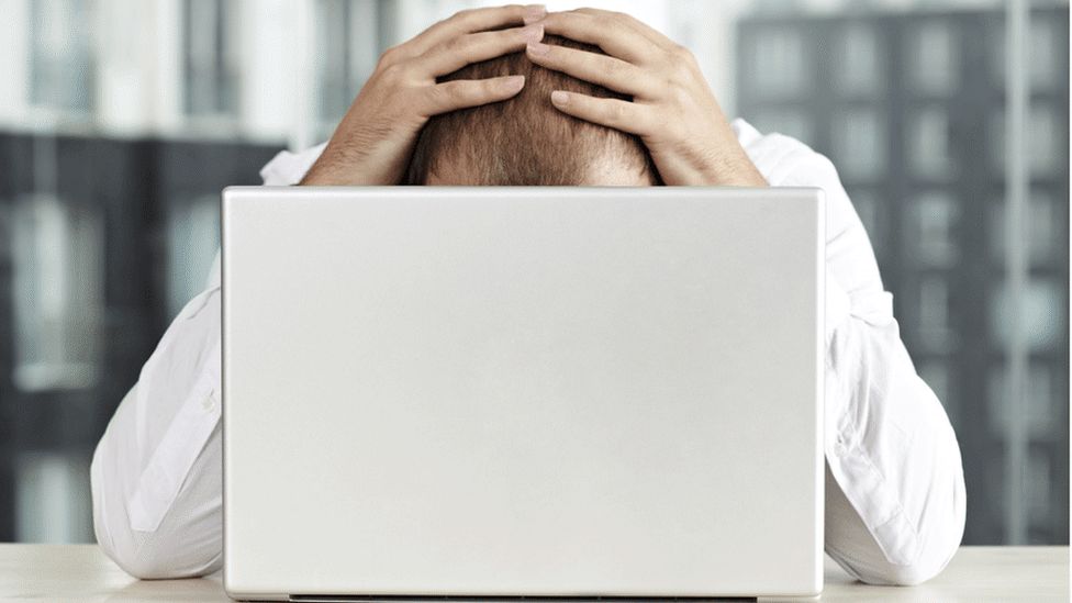Person looking stressed at computer