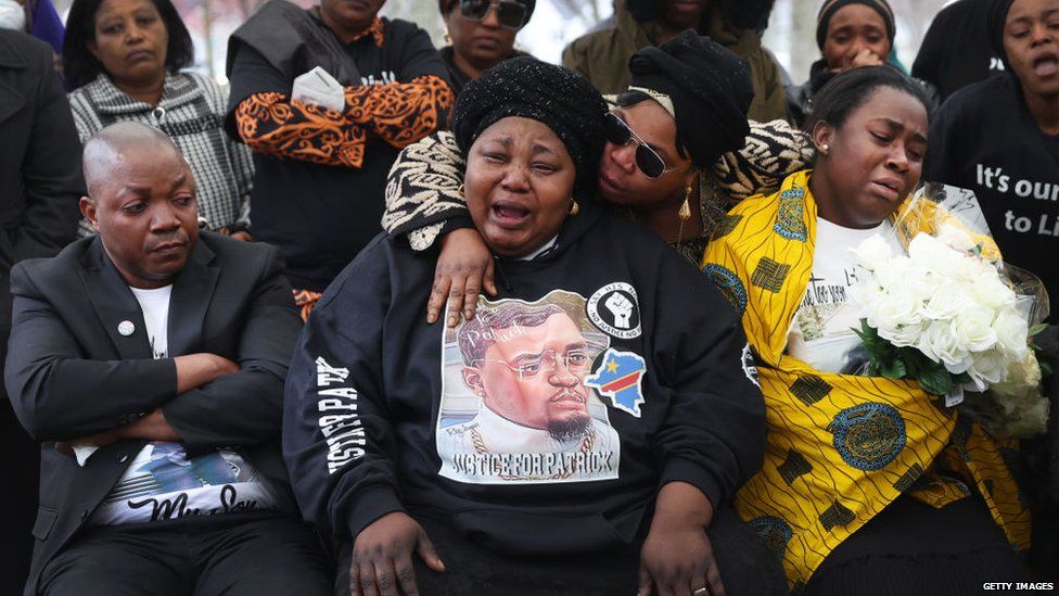 Доркас Лёя (в центре), мать Патрика Лёйи, скорбит на похоронах своего сына после того, как он был застрелен полицейским из Мичигана во время обычной остановки движения