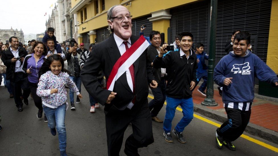Children play with a man impersonating the new Peruvian president