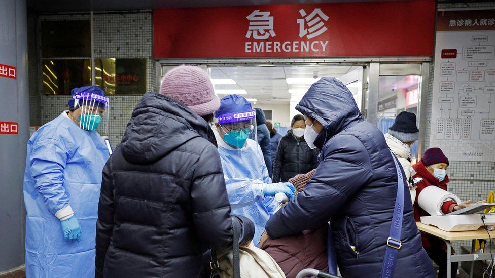 A medical worker conducts pre-examination on a patient on 26/12 amid surging numbers of emergency treatments at Tongji hospital in Shanghai