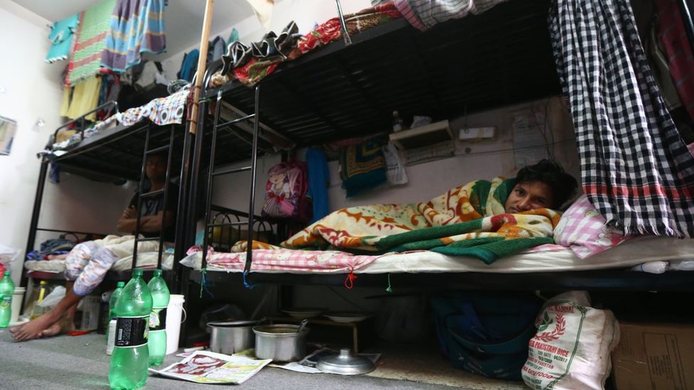 A Bangladeshi worker rest in bed in a private labour camp in Qatar
