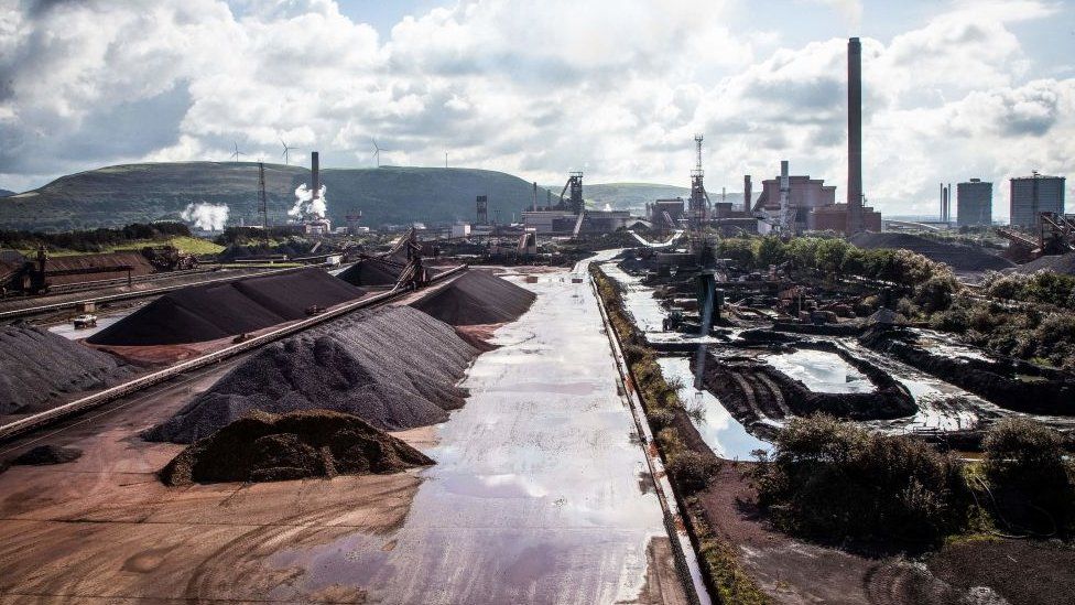 Raw materials to make iron sit in heaps at the steel works in Port Talbot