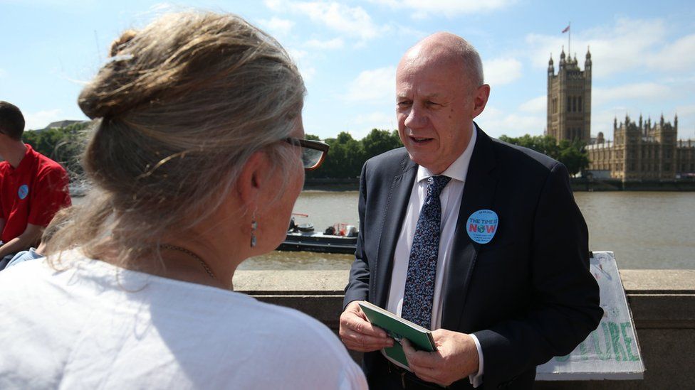Tory MP Damian Green talks to one of his constituents on the protest