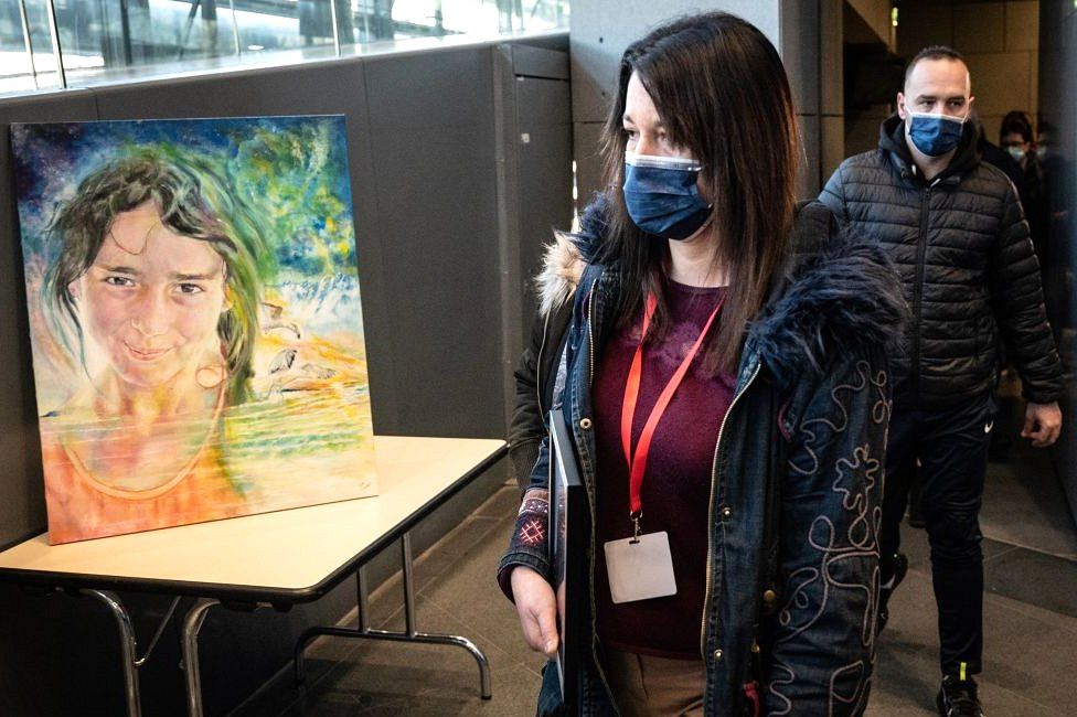 Jennifer Cleyet-Marrel walks by a painting of her daughter Maëlys as she arrives at the Grenoble courthouse where the trial of Nordahl Lelandais who is accused of her murder is taking place on 1 February 2022