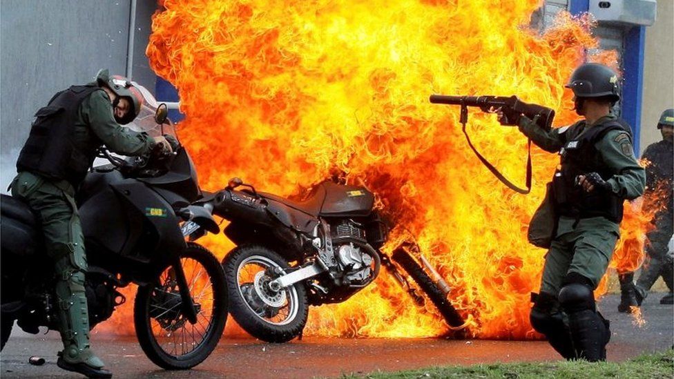Security forces clash with demonstrators as a motorcycle is set on fire during a protest against Venezuelan President Nicolas Maduro's government in San Cristobal, Venezuela May 29, 2017.