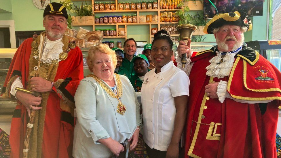 Image of the mock mayor, mayor, Maggie and the town crier at the opening of Ma's African Kitchen