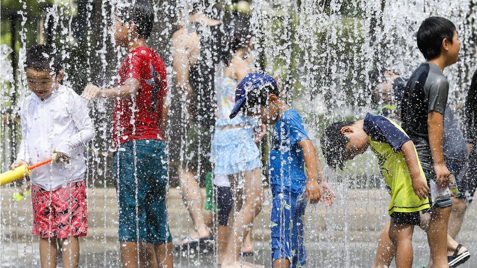 Children play in the water jets at a park near Nerima in Tokyo, Japan, 23 July 2018