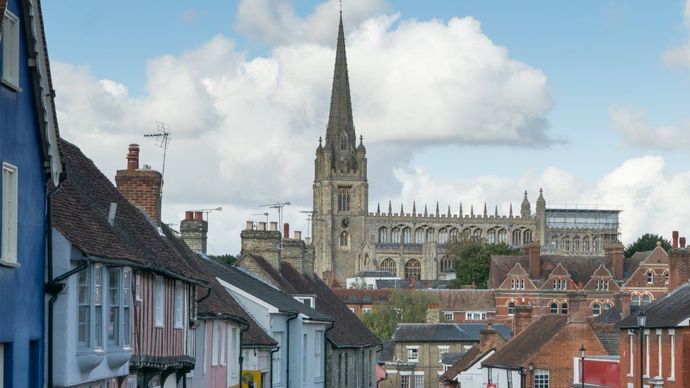 A street on a hill in Saffron Walden, with its cathedral in the background