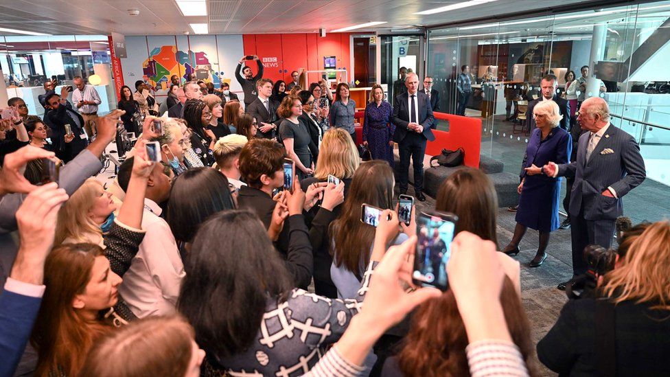 A crowd of journalists listen to Prince Charles and Camilla
