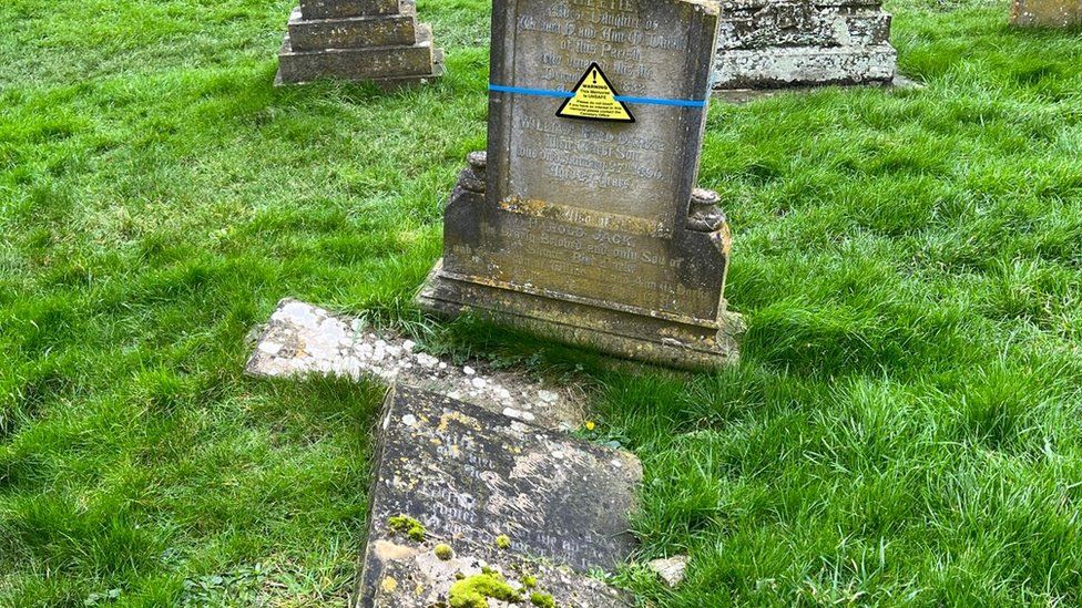 A headstone with a warning label on it