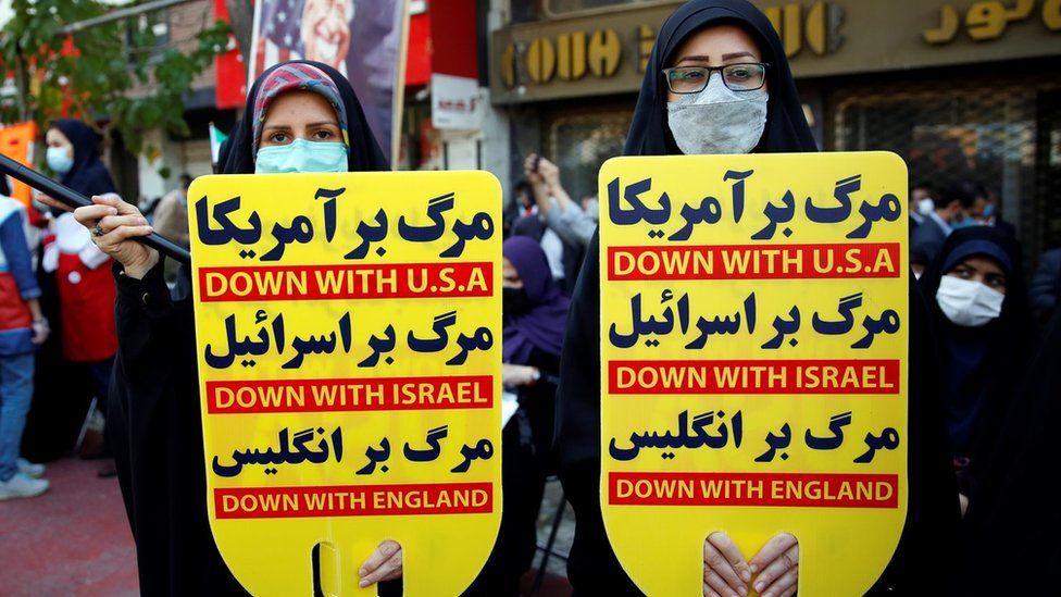 Iranian women carry placards during an anti-US protest marking the 42nd anniversary of US embassy takeover in Tehran, Iran (4 November 2021)