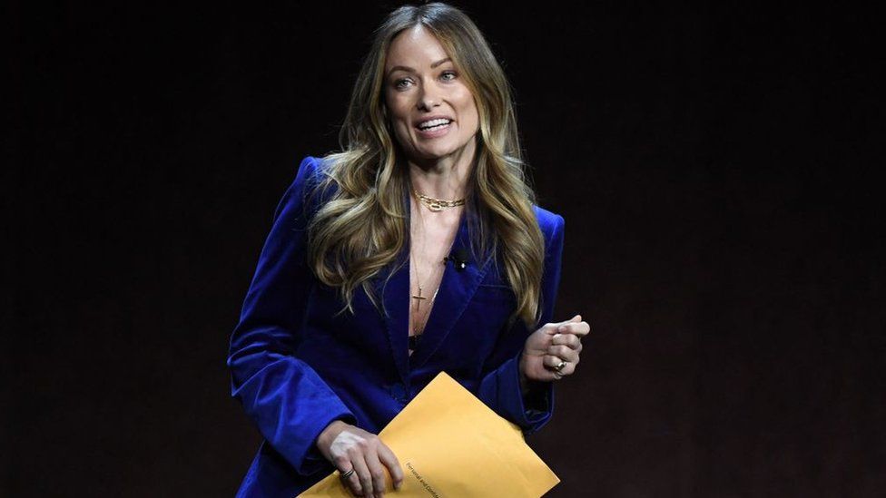 Olivia Wilde holding the letter while on stage in a theatre in Las Vegas on Tuesday