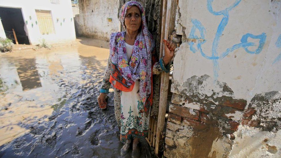 Женщина стоит возле своего дома после наводнения в районе Чарсадда, провинция Хайбер-Пахтунхва, Пакистан, 28 августа 2022 г.