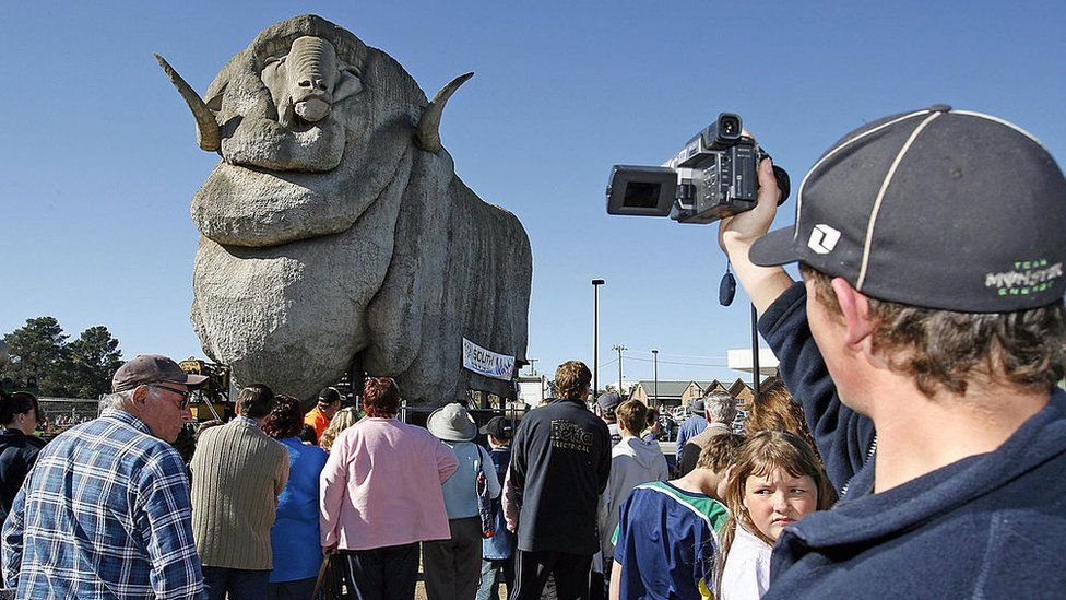 People stand in front of the Big Merino in Goulburn, New South Wales, after it was moved to a new location in 2007