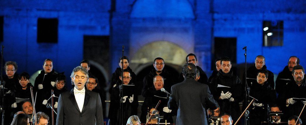Italian opera star Andrea Bocelli (L) performs on stage with the Abruzzo Symphony Orchestra at the Colosseum in Rome on May 25, 2009