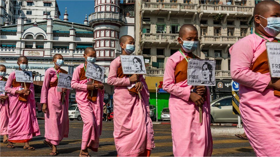 Buddhist monks hold placards featuring images of Aung San Suu Kyi during a protest on February 13, 2021 in Yangon, Myanmar.