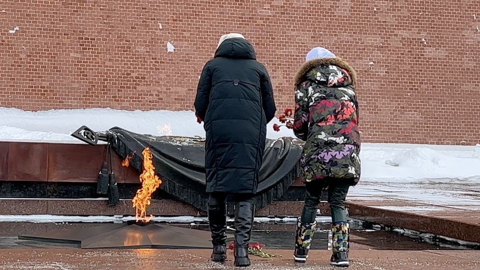 Two women lay flowers at the wall of the Kremlin