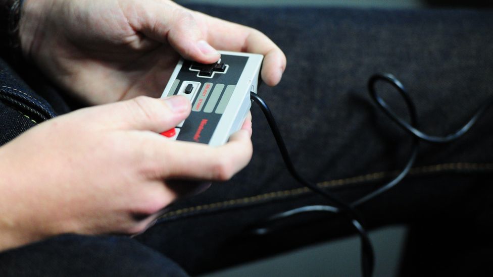 Person holding a NES controller.