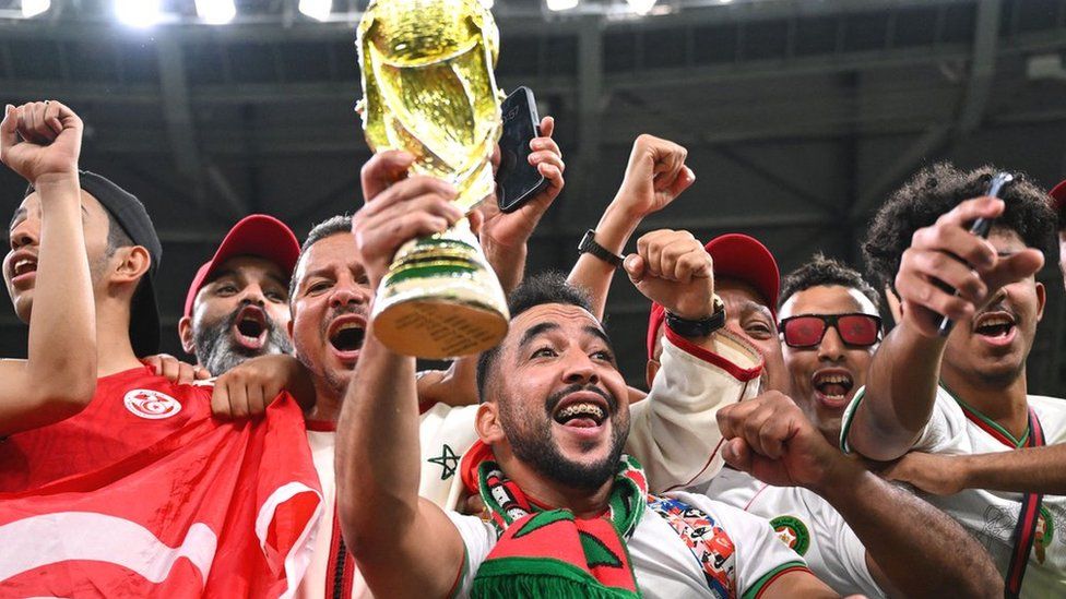 Morocco football fans hold a replica World Cup trophy in Qatar