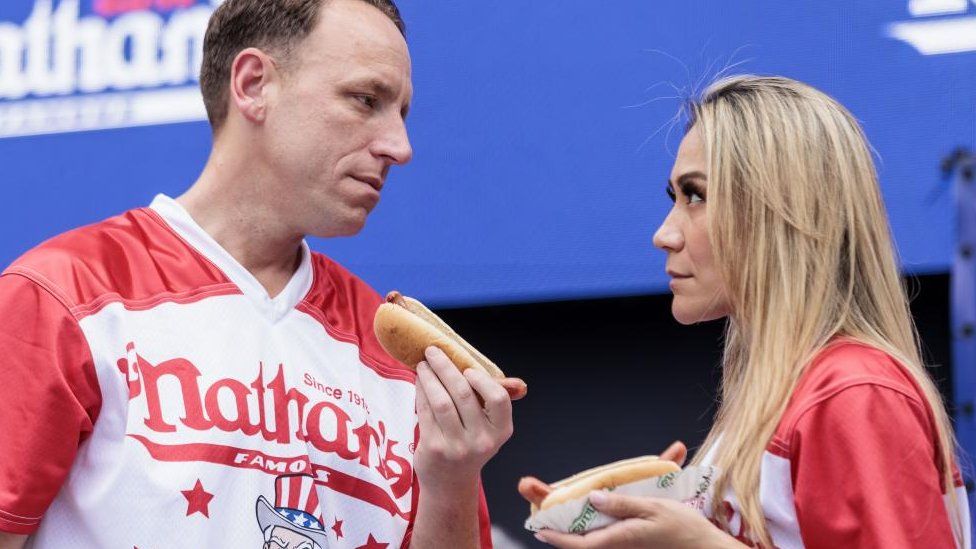 Joey Chestnut (izda.) y Miki Sudo (dcha.), los mejores competidores, se enfrentan durante la ceremonia de pesaje del Concurso Internacional de Perritos Calientes Nathan's Famous del 4 de julio en Nueva York, Estados Unidos, el 3 de julio de 202