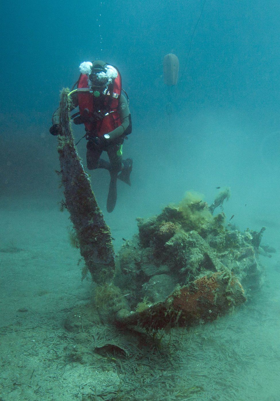 A French military diver member of the FS Pluton M622 navy de-mining ship, swims on July 2, 2018, above the wreck of an USAAF P-47 Thunderbolt (Warthog) US fighter plane