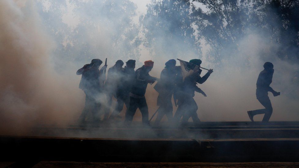 Farmers, who are marching towards New Delhi to press for better crop prices promised to them in 2021, run for cover amidst tear gas fired by police to disperse them at Shambhu barrier, a border crossing between Punjab and Haryana states, India, February 21, 2024.
