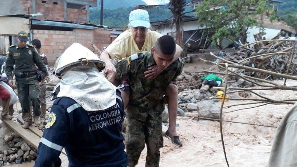 A woman is rescued from the landslide by a Colombian soldier