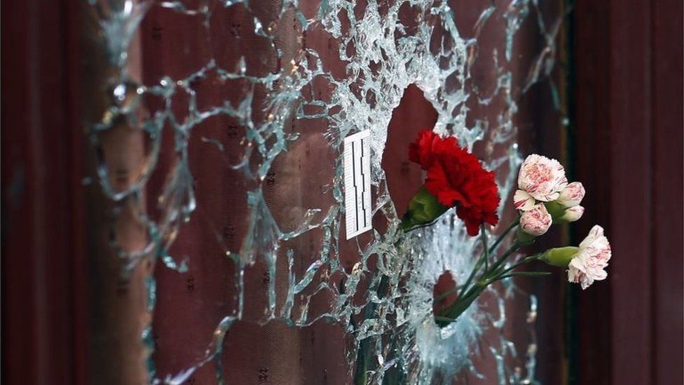 Flowers in a window shattered by a bullet at the Carillon cafe - one of the sites of the 13 November attacks in Paris