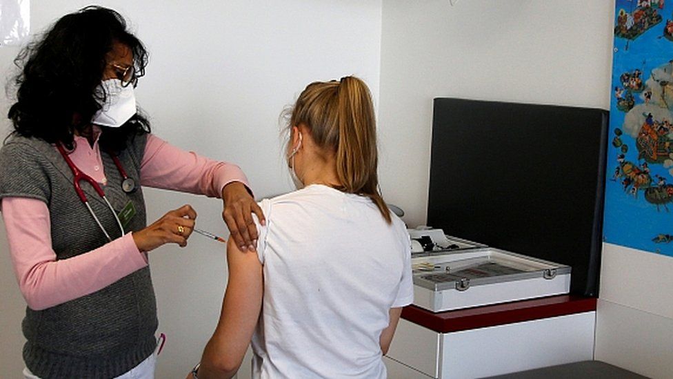 Анила Штернберг вакцинирует девочку-подростка дозой вакцины Pfizer-BioNtech в Бонне, Германия, 21 мая 2021 г.