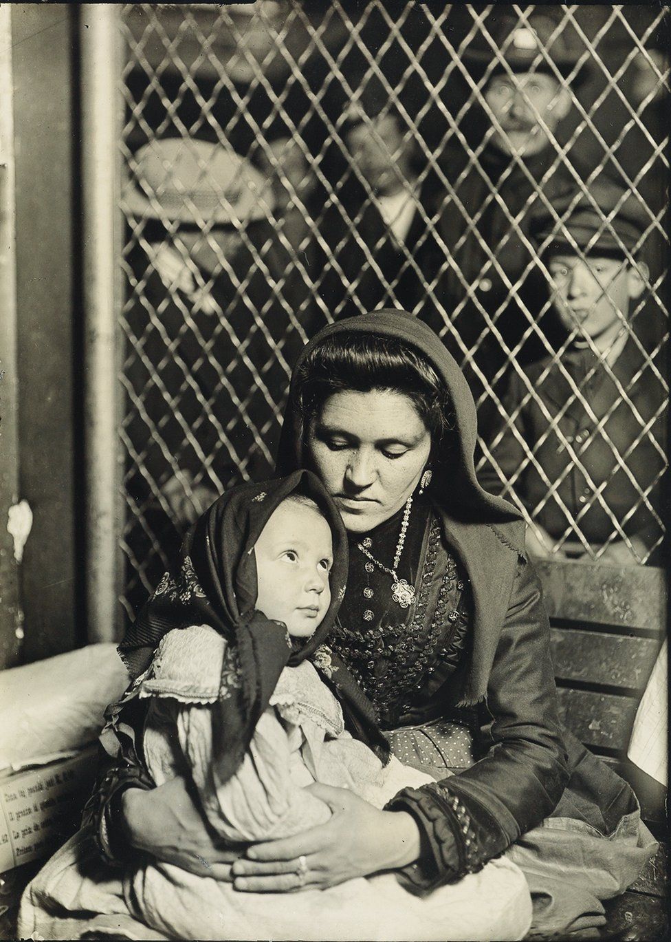 A mother holds her child in her lap.